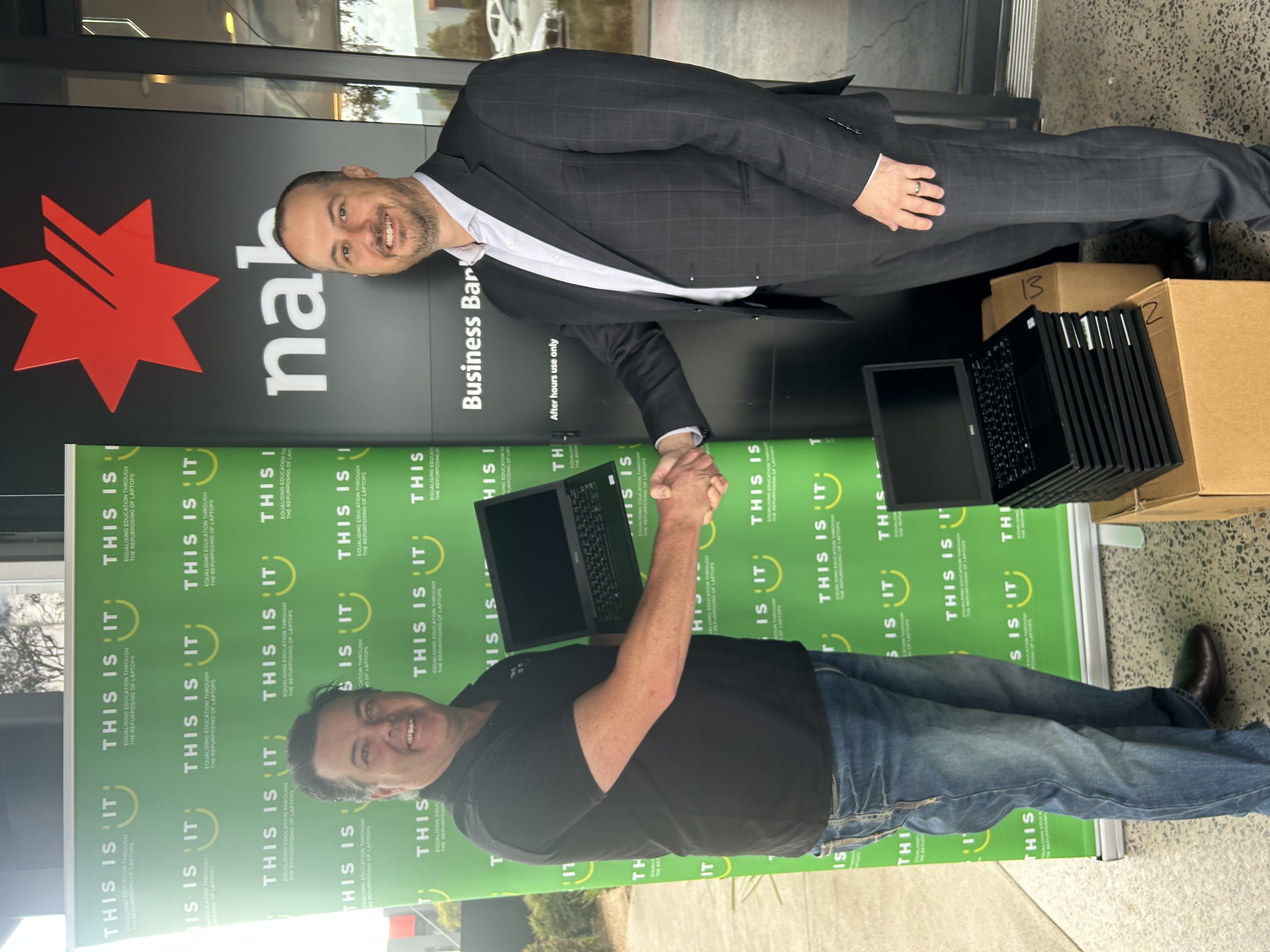 A corporate donor handing over laptops to This Is IT